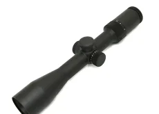 Black rifle scope with adjustable turrets and lens at either end, viewed from a tilted angle against a white background
